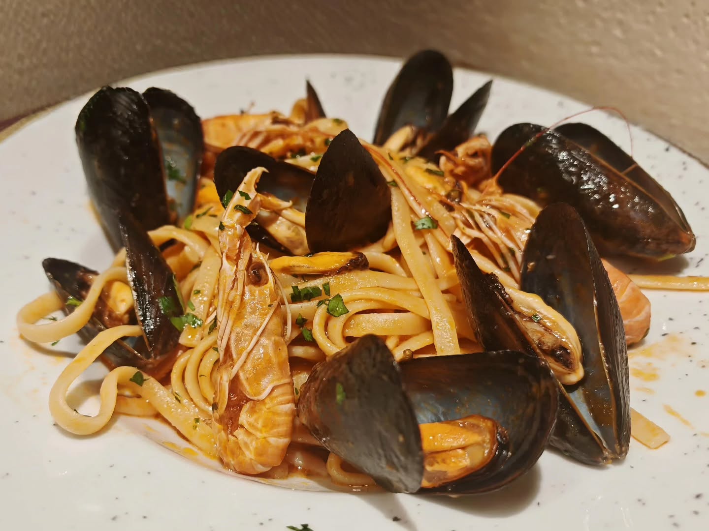 Cozze e scampi,un profumo di Mediterraneo che avvolge ogni forchettata. Un piatto semplice, ma intenso, da gustare con lentezza e un buon bicchiere di bianco. Mussels and langoustines, a Mediterranean aroma that embraces every bite. A simple yet intense dish, to be savored slowly with a good glass of white wine.