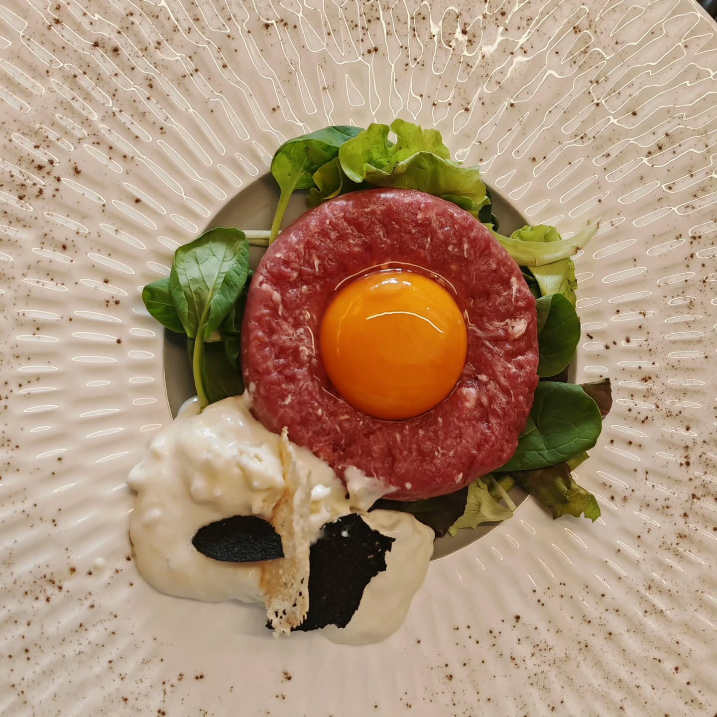 Tartare di manzo con uovo fresco e crema. Beef tartare with fresh egg and cream.